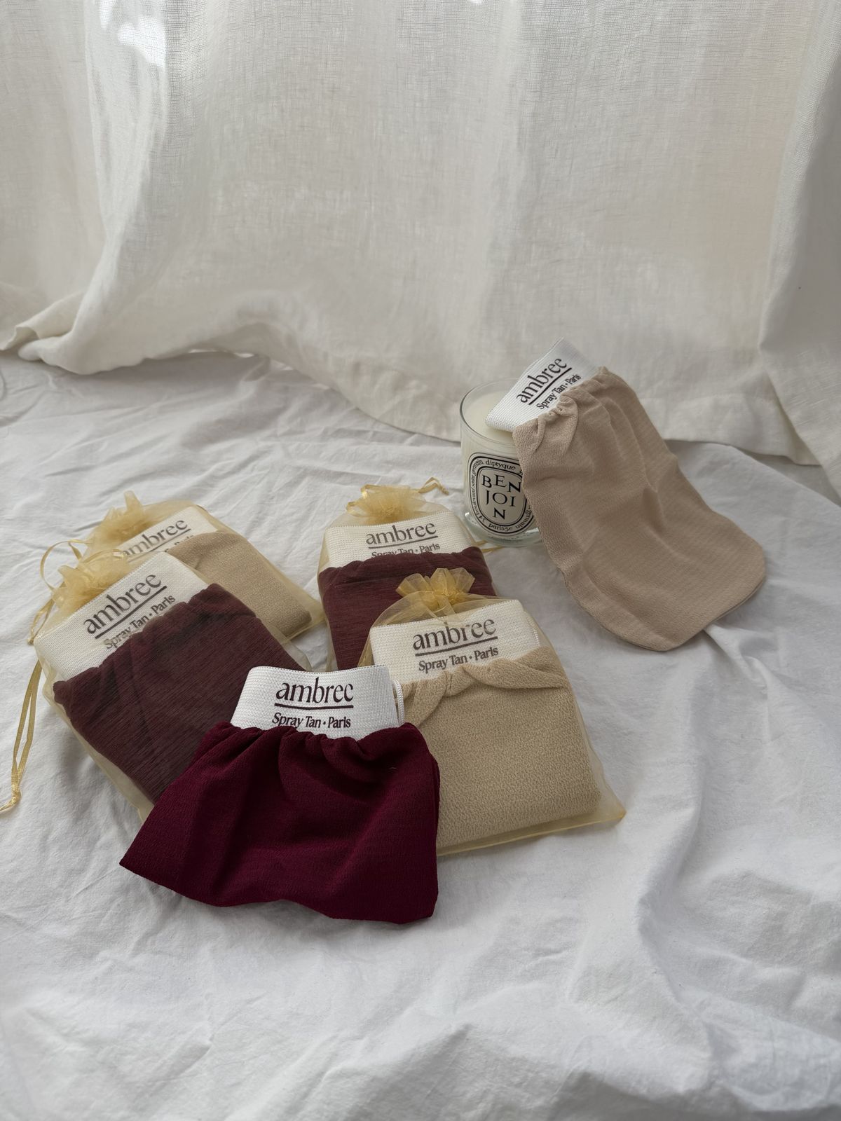 Gants kessa ambree bordeaux et sable dans leur pochette en organza doré